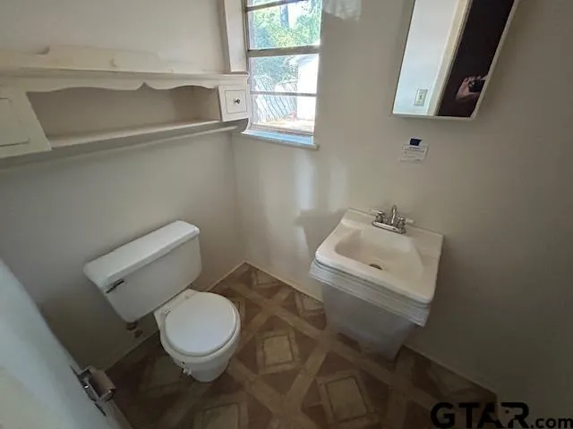 a white toilet sitting next to a bathroom sink