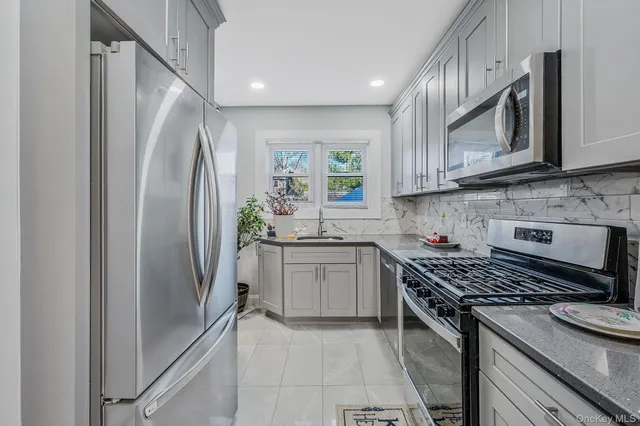 a kitchen with stainless steel appliances granite countertop a refrigerator sink and stove