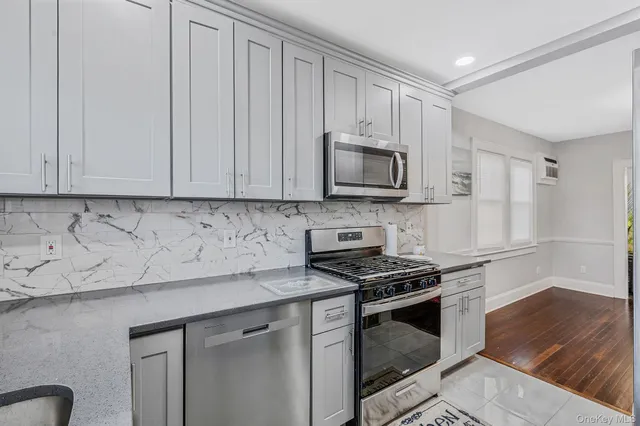 a kitchen with granite countertop a stove a sink and a microwave