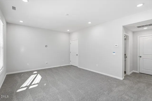 an empty room with a ceiling fan and window