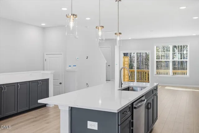 a kitchen with a sink a center island wooden floor and a window