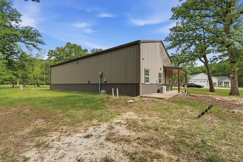 7366 Point Aquarius Quinlan, TX 75474 - Photo 26 of 30 a backyard of a house with plants and large tree