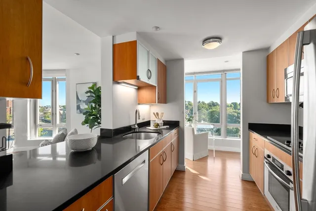 a kitchen with a sink stove and wooden floor