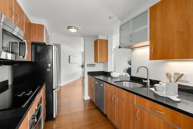 a kitchen with stainless steel appliances granite countertop a sink stove and refrigerator