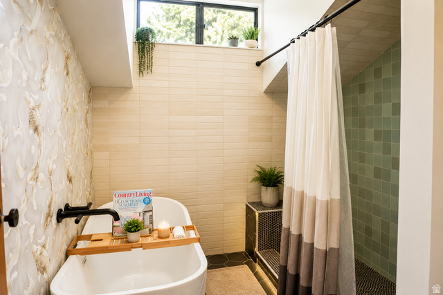 578 High Bench Road Alpine, UT 84004 - Photo 27 of 39 Freestanding soaking tub with wall-mounted matte black faucet, hexagonal floor tiling, and a tiled shower stall with pebble-finish flooring