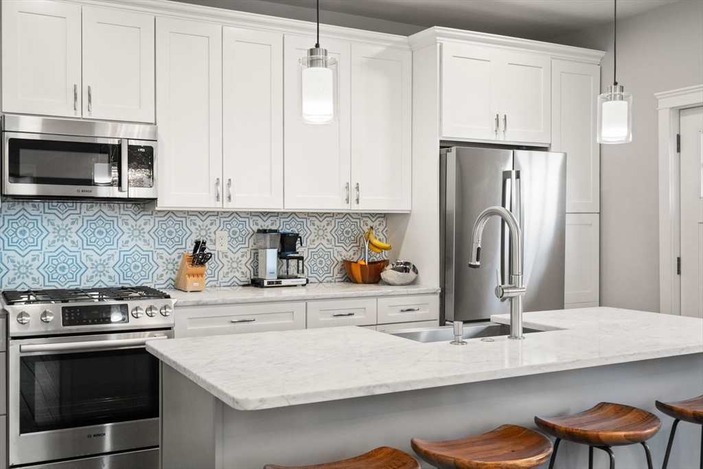 91 Glen Road, Unit 2 Boston, MA 02130 - Photo 5 of 31 a kitchen with stainless steel appliances a stove refrigerator sink and cabinets