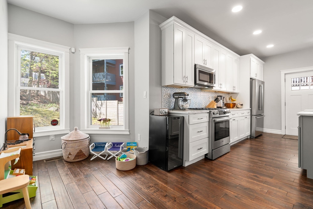 91 Glen Road, Unit 2 Boston, MA 02130 - Photo 6 of 31 a kitchen with stainless steel appliances a stove a sink a refrigerator wooden floor and cabinets