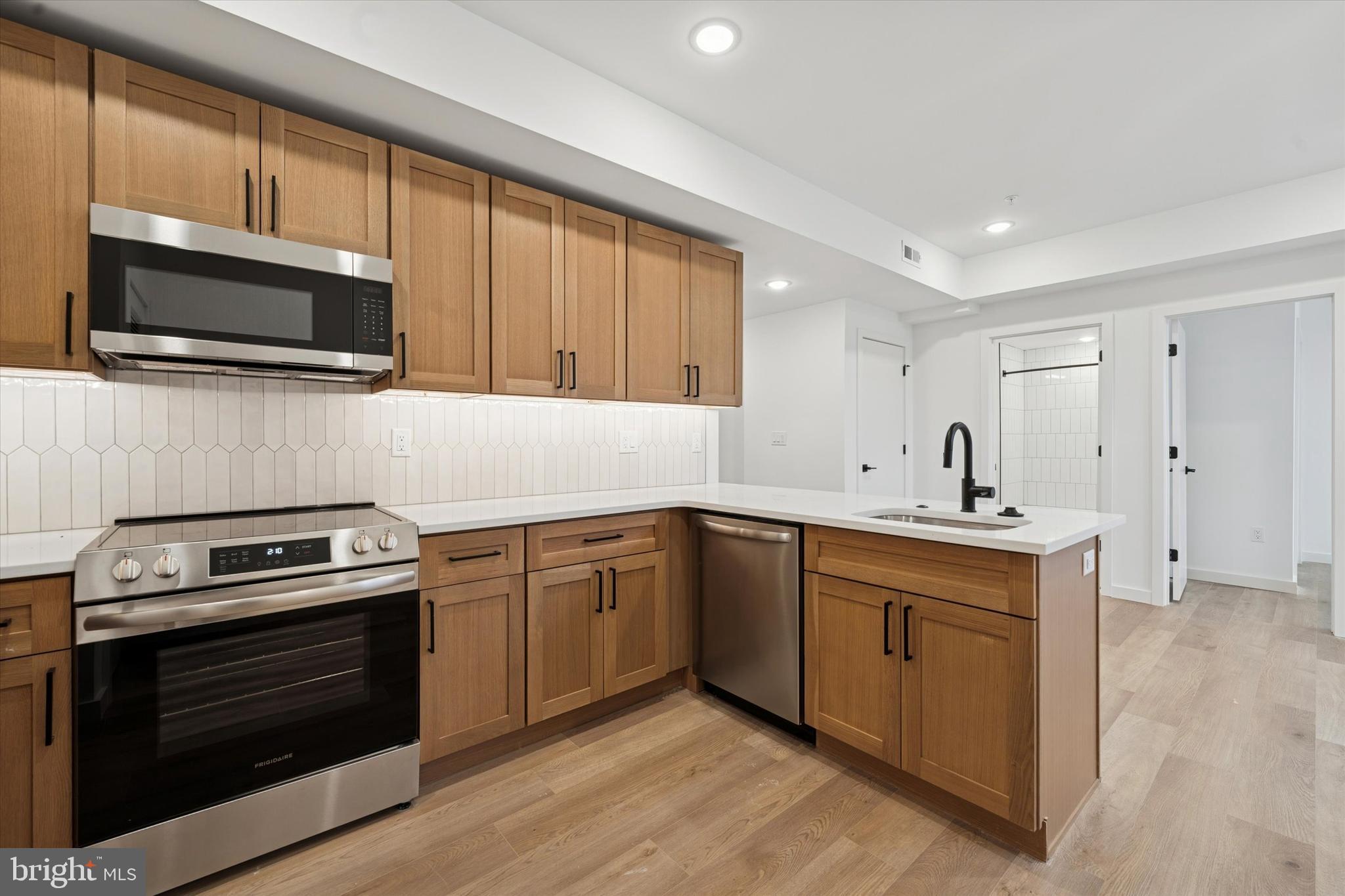 a kitchen with stainless steel appliances a stove microwave and sink