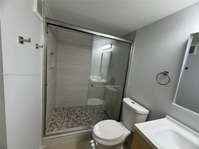 a white toilet sitting next to a bathroom sink