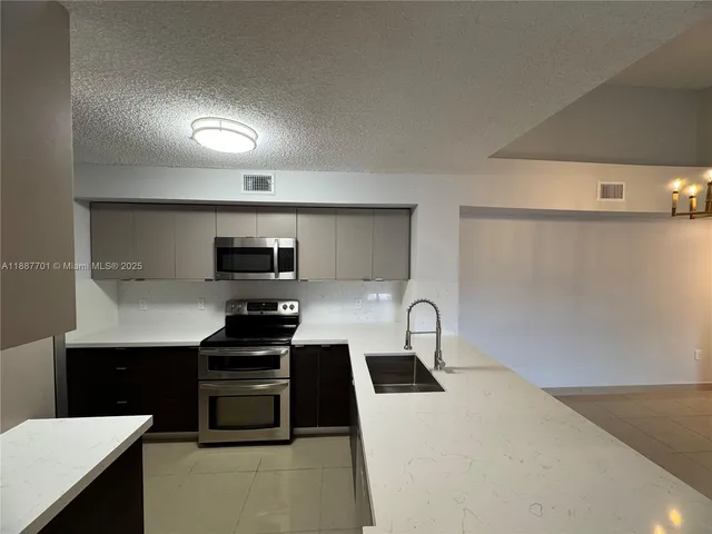 a kitchen with a sink a stove and cabinets
