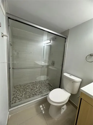 a white toilet sitting next to a shower