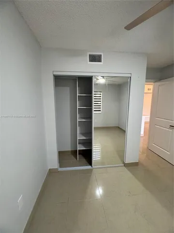 an empty room with a fireplace and cabinet