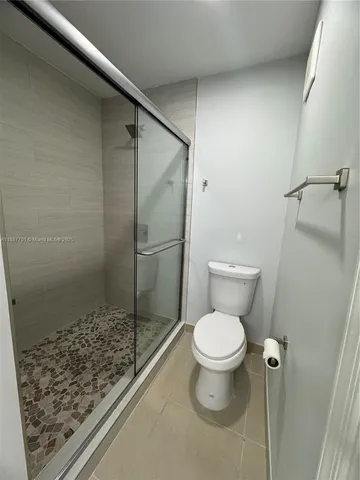 a bathroom with a toilet and a shower
