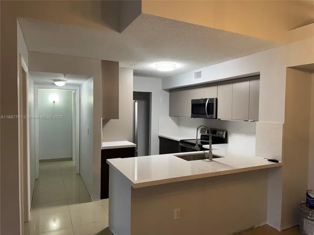 a kitchen with stainless steel appliances a sink and a refrigerator