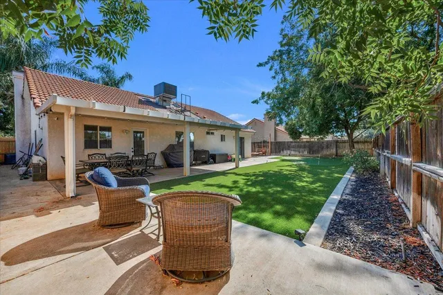 a view of a house with a yard and a patio