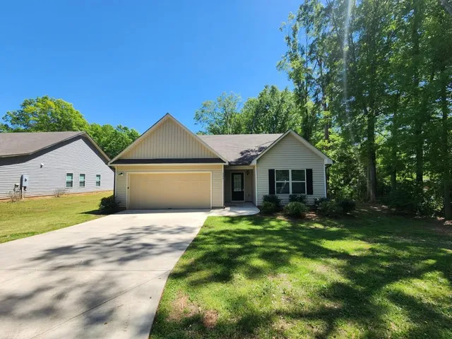 a front view of a house with yard and green space