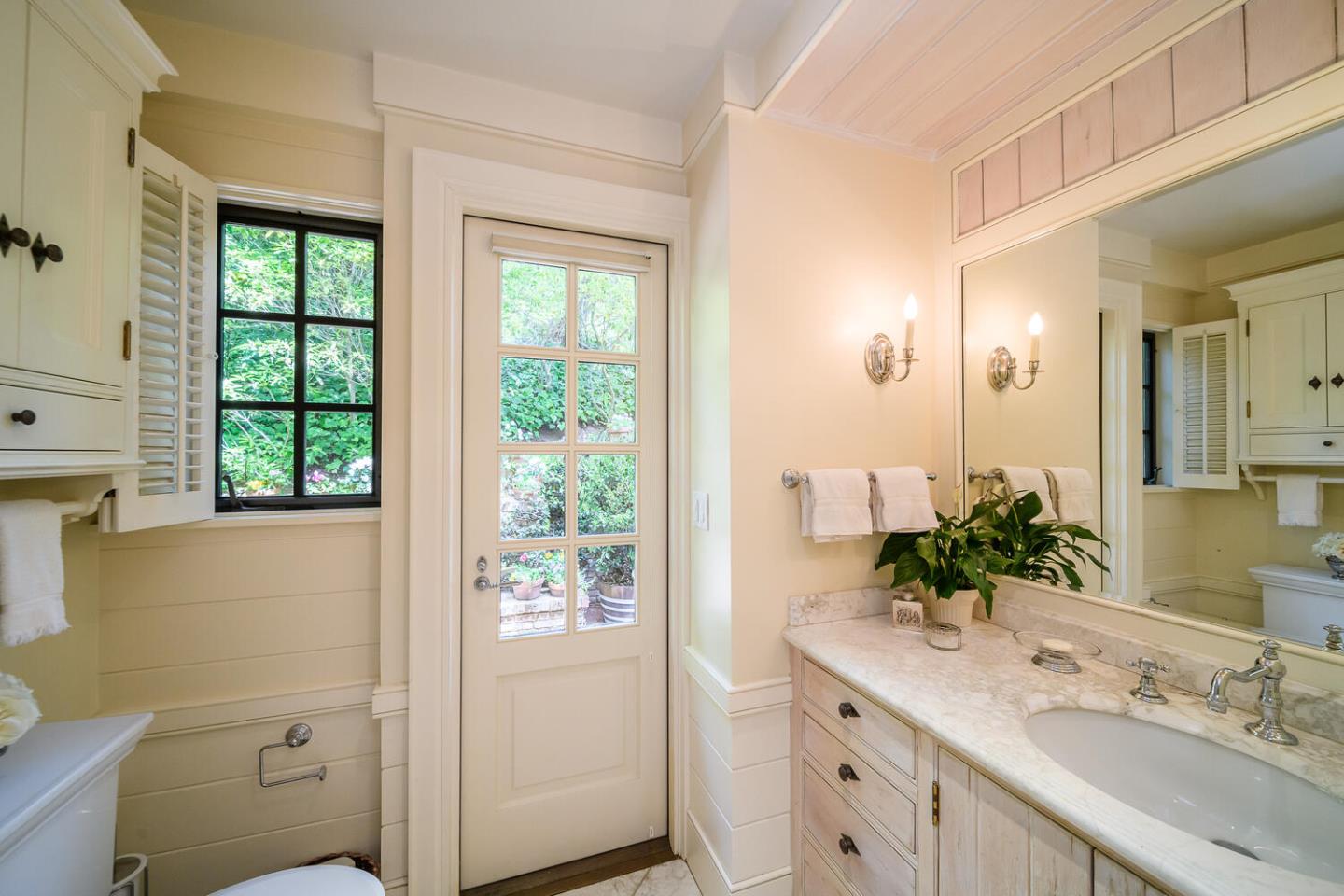 100 Robin Road Hillsborough, CA 94010 - Photo 31 of 90 a bathroom with a granite countertop sink a large mirror a and a window