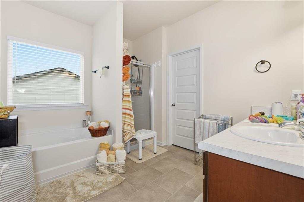 223 Malbone Street Southwest Cartersville, GA 30120 - Photo 19 of 38 a bathroom with a sink a bathtub and next to a window