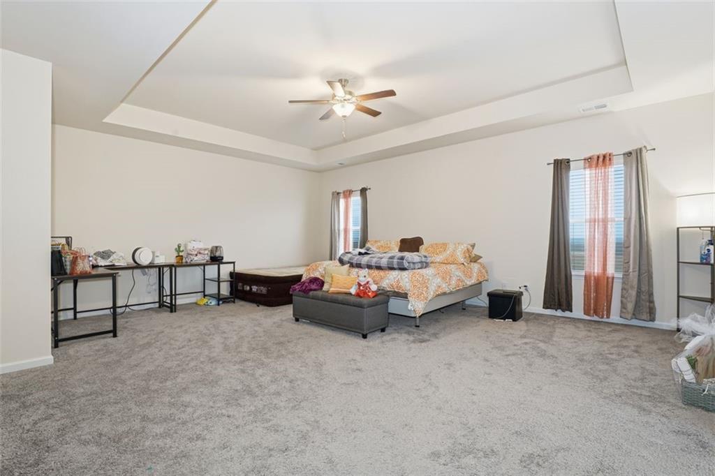 223 Malbone Street Southwest Cartersville, GA 30120 - Photo 21 of 38 a spacious bedroom with a bed and a chandelier