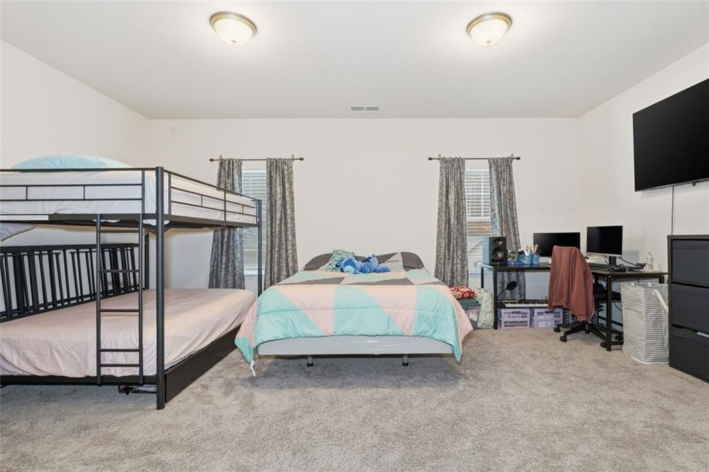 223 Malbone Street Southwest Cartersville, GA 30120 - Photo 27 of 38 a bedroom with a bed and flat tv screen on the dresser