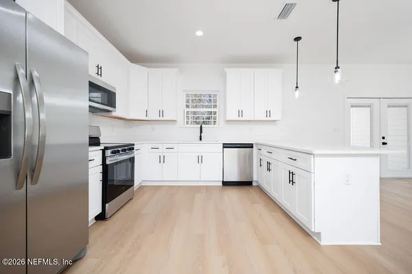 a kitchen with stainless steel appliances a refrigerator sink and cabinets