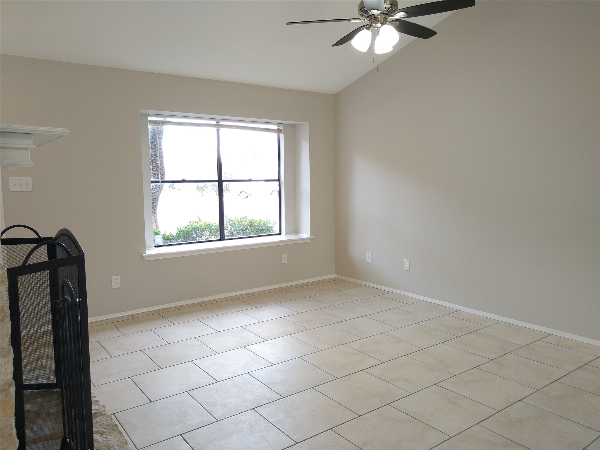 1813 Laurel Path Round Rock, TX 78664 - Photo 8 of 35 A generous window illuminates the neutral-toned living space, featuring practical tile flooring and a ceiling fan.