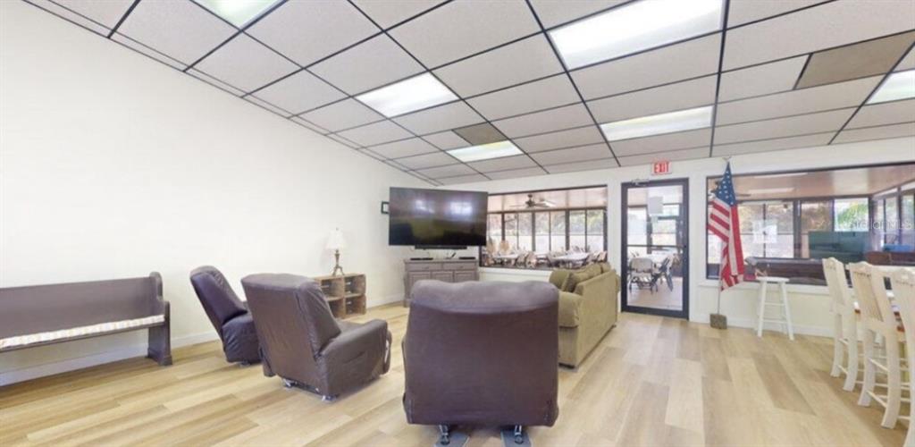 1074 Front Street, Unit 51 Welaka, FL 32193 - Photo 9 of 27 a living room with furniture a flat screen tv and floor to ceiling window