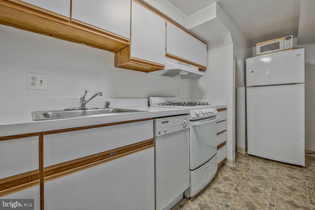 2406 37th Street Northwest Washington, DC 20007 - Photo 29 of 44 a kitchen with a sink and a refrigerator