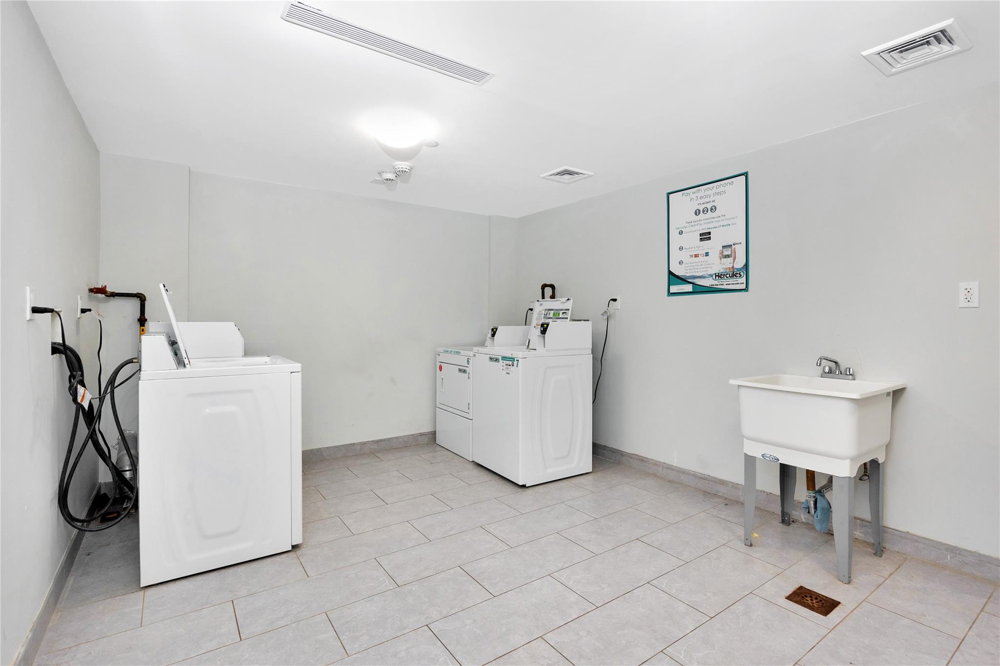 148-36 89th Avenue, Unit 3C Queens, NY 11435 - Photo 22 of 27 Community laundry room featuring washer and dryer and visible vents