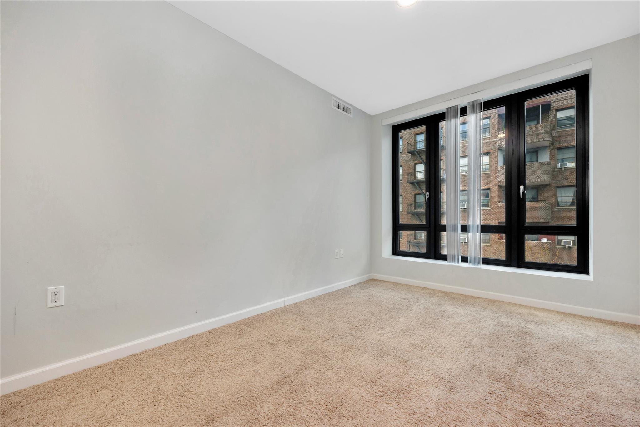 148-36 89th Avenue, Unit 3C Queens, NY 11435 - Photo 6 of 27 Carpeted empty room with visible vents and baseboards