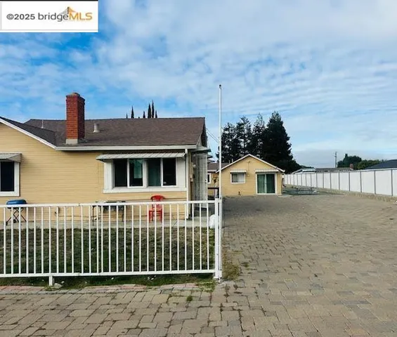 a view of a white house with wooden fence