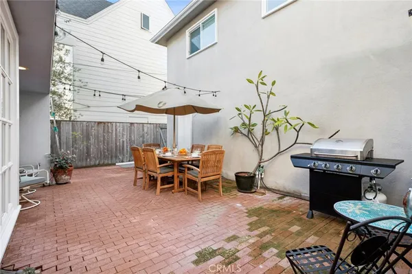 a view of a patio with table and chairs with wooden fence