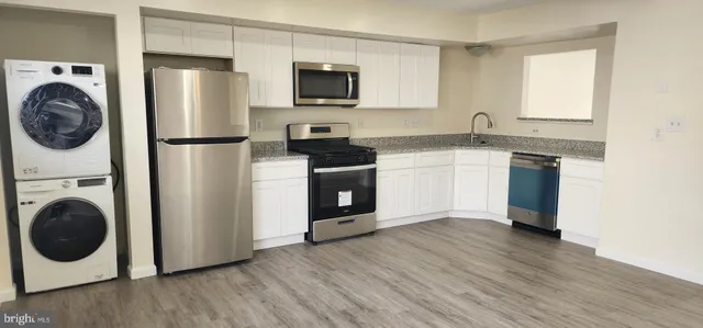 a kitchen with a refrigerator and a stove top oven