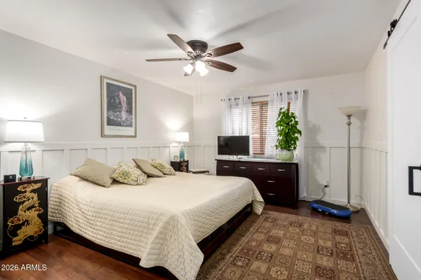 a bedroom with a bed and a flat tv screen on the dresser