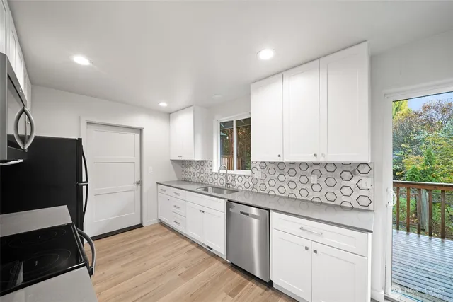 a kitchen with granite countertop white cabinets and refrigerator