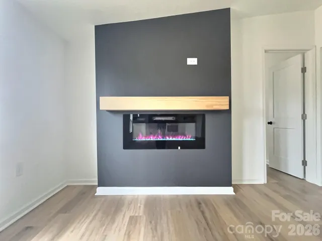 a view of empty room with wooden floor and window