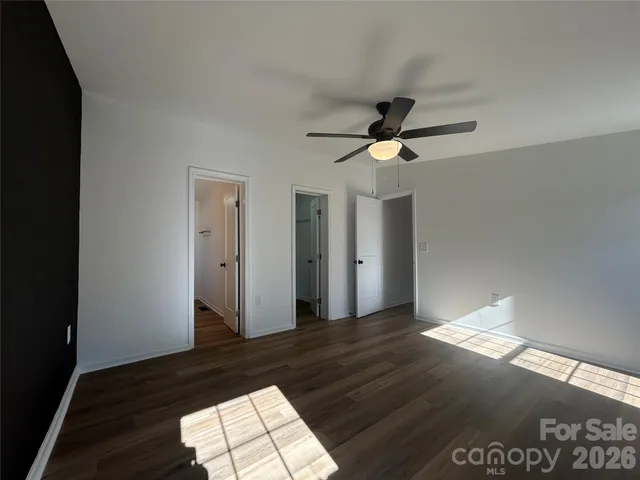a view of empty room with wooden floor and window