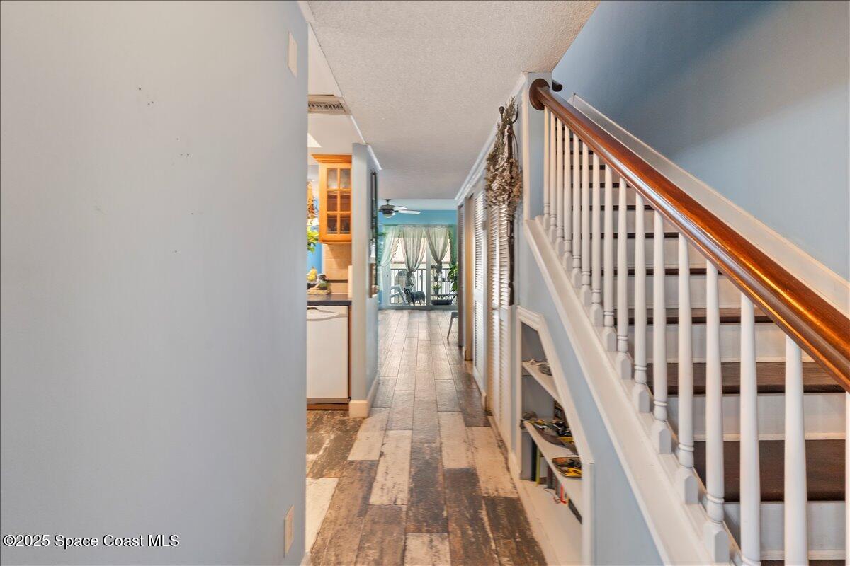 199 Florida A1A, Unit D201 Satellite Beach, FL 32937 - Photo 17 of 39 a view of staircase with lots of frames on wall and wooden floor