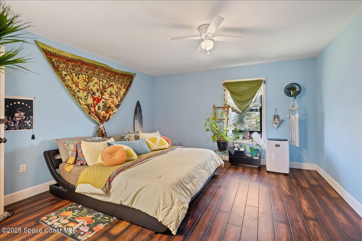 199 Florida A1A, Unit D201 Satellite Beach, FL 32937 - Photo 19 of 39 a bedroom with a bed and wooden floor