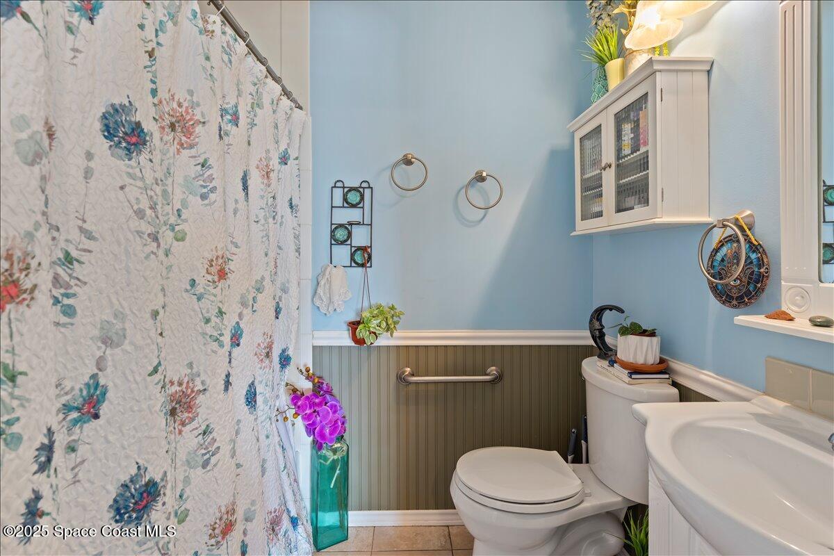 199 Florida A1A, Unit D201 Satellite Beach, FL 32937 - Photo 29 of 39 a bathroom with a toilet a sink and a shower curtain