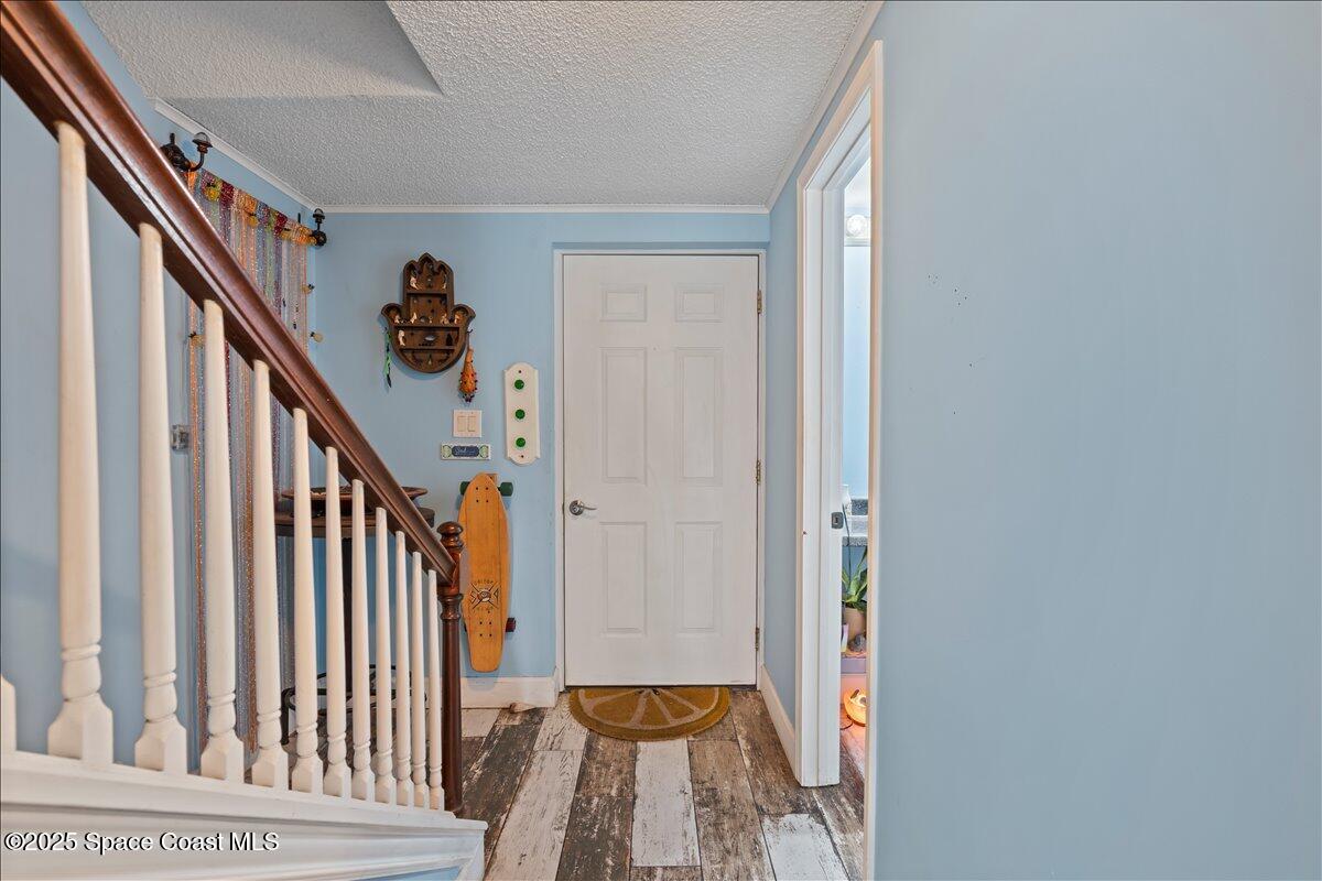 199 Florida A1A, Unit D201 Satellite Beach, FL 32937 - Photo 5 of 39 a view of a hallway with wooden floor and staircase