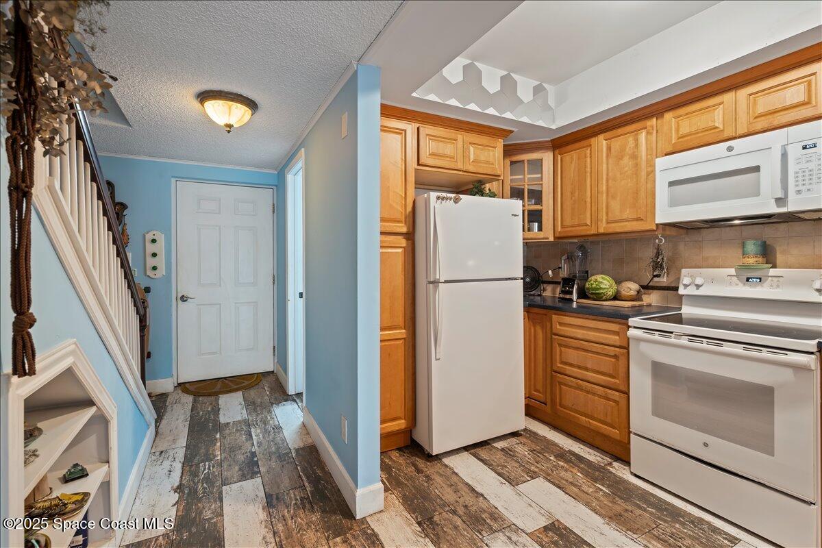 199 Florida A1A, Unit D201 Satellite Beach, FL 32937 - Photo 7 of 39 a kitchen with refrigerator a stove a washer and dryer
