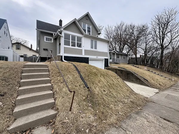 a front view of a house with a yard covered with snow