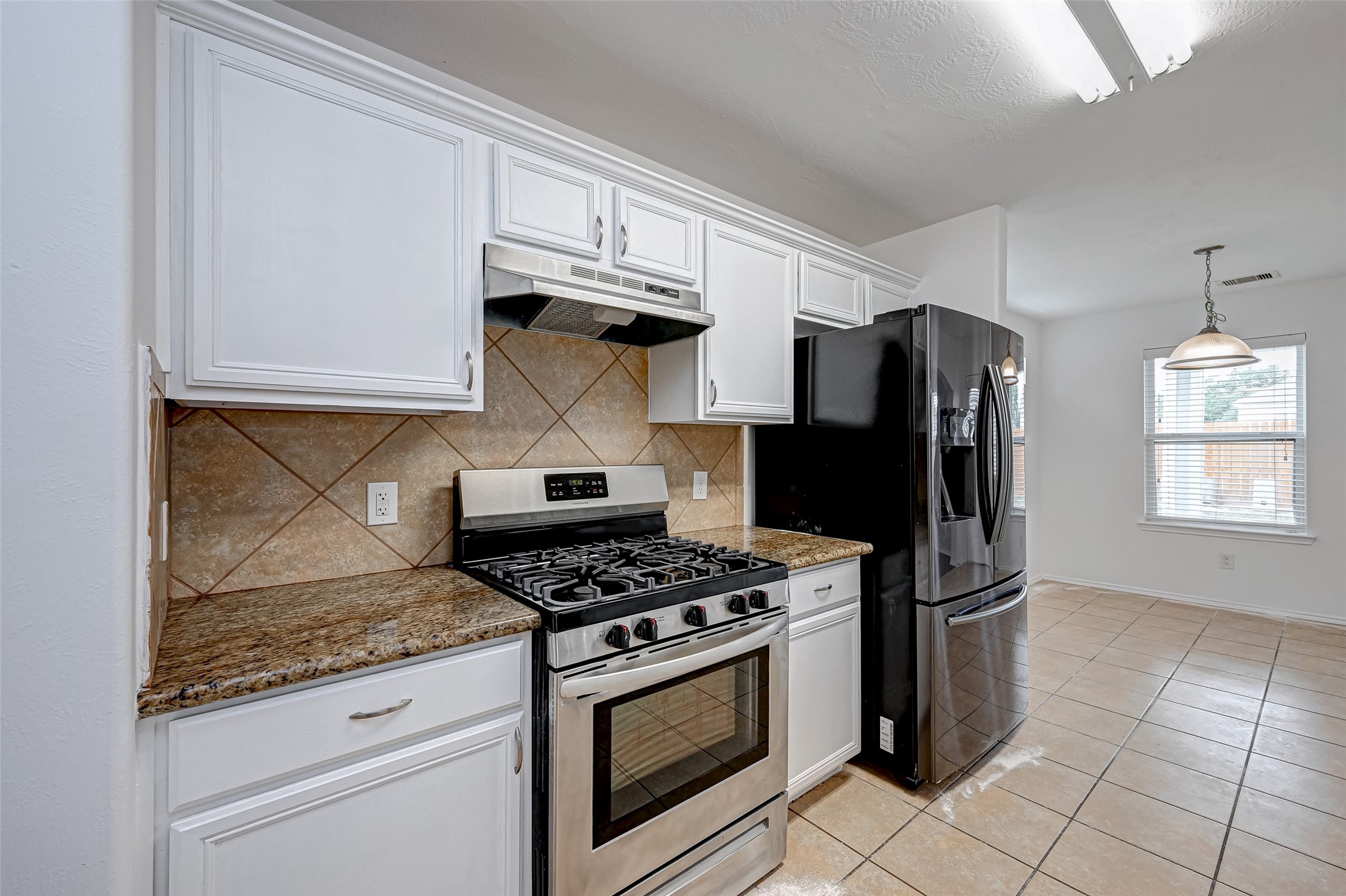 6906 Anson Point Lane Houston, TX 77040 - Photo 13 of 31 a kitchen with granite countertop a stove and a refrigerator