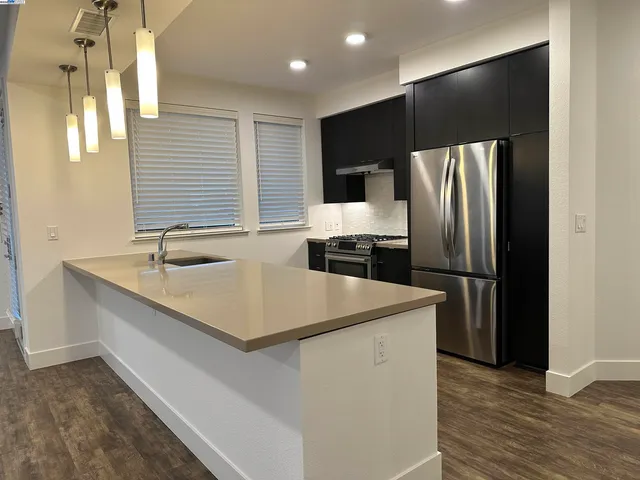 a kitchen that has a sink stainless steel appliances a counter space and a window