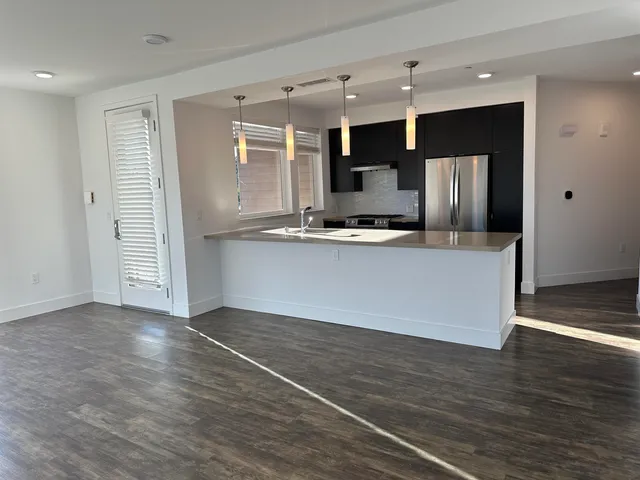a kitchen with stainless steel appliances a refrigerator and a stove top oven