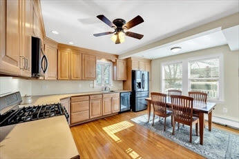 44 Holmes Road Dedham, MA 02026 - Photo 3 of 24 a kitchen with stainless steel appliances granite countertop a dining table chairs sink and cabinets