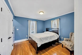 44 Holmes Road Dedham, MA 02026 - Photo 5 of 24 a bedroom with a bed and wooden floor