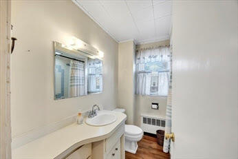 44 Holmes Road Dedham, MA 02026 - Photo 6 of 24 a bathroom with a sink toilet a mirror and vanity