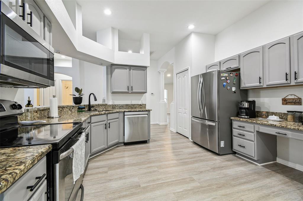 11478 Weston Course Loop Riverview, FL 33579 - Photo 12 of 30 a kitchen with a refrigerator a sink dishwasher a stove top oven a refrigerator with grey cabinets and wooden floor